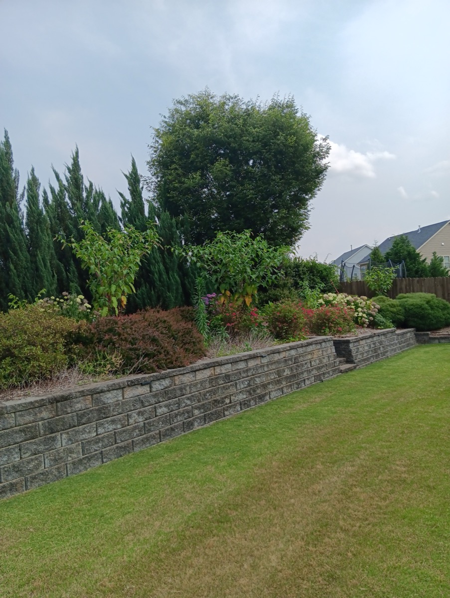 Long stone retaining wall with landscaping