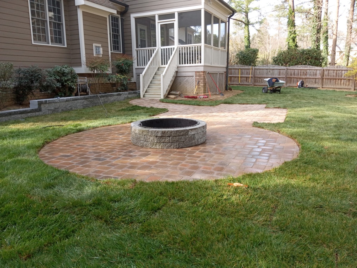 Paver patio with stone fire pit and walkway by HRJ Lawn and Landscapes